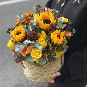 Композиция в сумке "Тональность" из подсолнухов, калл, ягод вибирнума, лимонных роз, скиммии и орхидеи в Домодедово